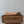 Hand-carved wood table with intricate rattan front panel and tools on top