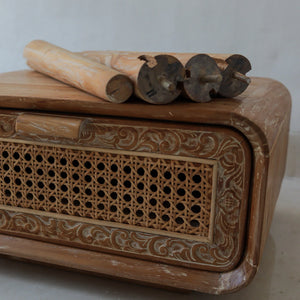 Hand-carved wooden furniture with woven rattan panel and ornate Balinese detail