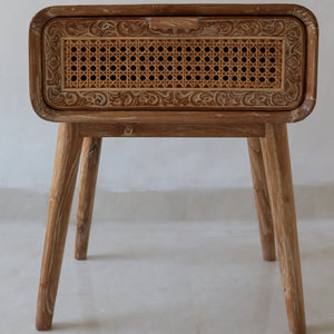 Hand-carved wooden side table with rattan drawer and intricate Balinese pattern.