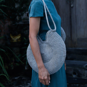 Wire Mesh Hand Woven Bag Ratna being held by a woman in a teal dress, showcasing its unique and eco-friendly design.