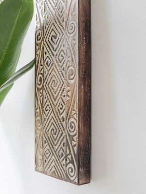 Hand-carved wooden wall decor with intricate geometric patterns and rustic finish