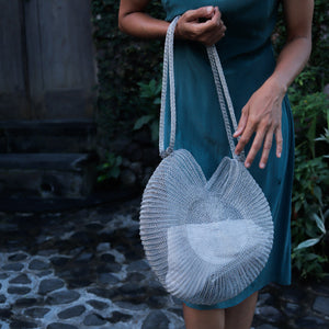 Wire Mesh Hand Woven Bag Ratna displayed by a model in a green dress, showcasing its unique handwoven design.