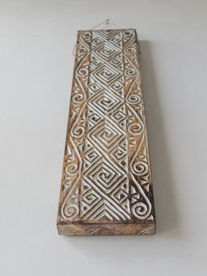 Hand-carved wooden wall panel with intricate geometric Balinese patterns
