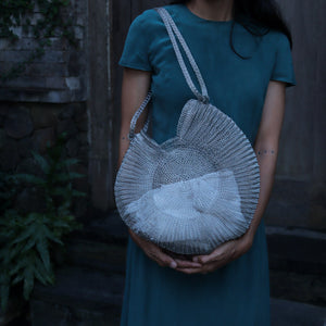 Wire Mesh Hand Woven Bag Ratna held by a model, showcasing its unique handwoven brass mesh design and eco-friendly features.