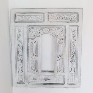 Hand-carved whitewashed wooden Balinese window frame with ornate floral patterns