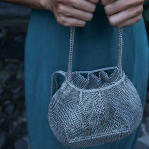 Wire Mesh Hand Woven Bag Lily held by a person showcasing its unique handwoven brass mesh design.
