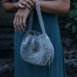Wire Mesh Hand Woven Bag Lily held by a person, showcasing a unique, eco-friendly handwoven brass design.