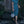 Woman in a blue dress holding a Wire Mesh Hand Woven Bag Lily while walking in a garden setting.