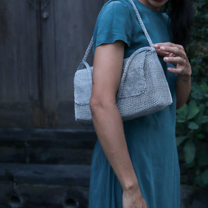 Wire Mesh Hand Woven Bag Melati held by a woman, showcasing its unique handwoven brass mesh design.