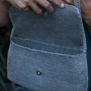 Wire Mesh Hand Woven Bag Melati held by a hand, showcasing its unique handwoven brass mesh texture.