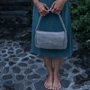 Wire Mesh Hand Woven Bag Melati held by a person, showcasing its unique handwoven brass mesh texture.