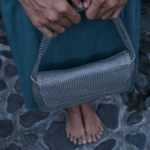 Woman holding Wire Mesh Hand Woven Bag Melati, showcasing its unique handwoven brass mesh design.