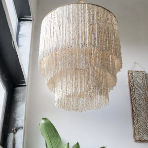 Handmade tiered seashell chandelier in a modern room with tropical decor