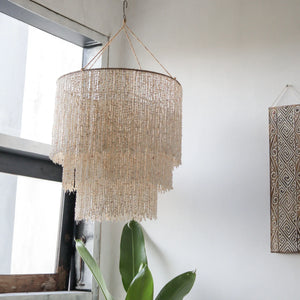 Handmade Balinese seashell chandelier hanging in a bright, modern room
