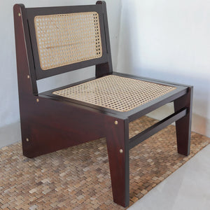 Teak wood lounge chair with woven rattan seat and backrest on a textured mat