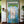 Hand-carved Balinese wooden door with blue, green, and white ornate patterns, tropical decor