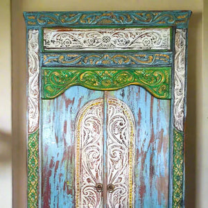 Hand-carved Balinese wooden door with detailed floral patterns, blue, green, and gold accents