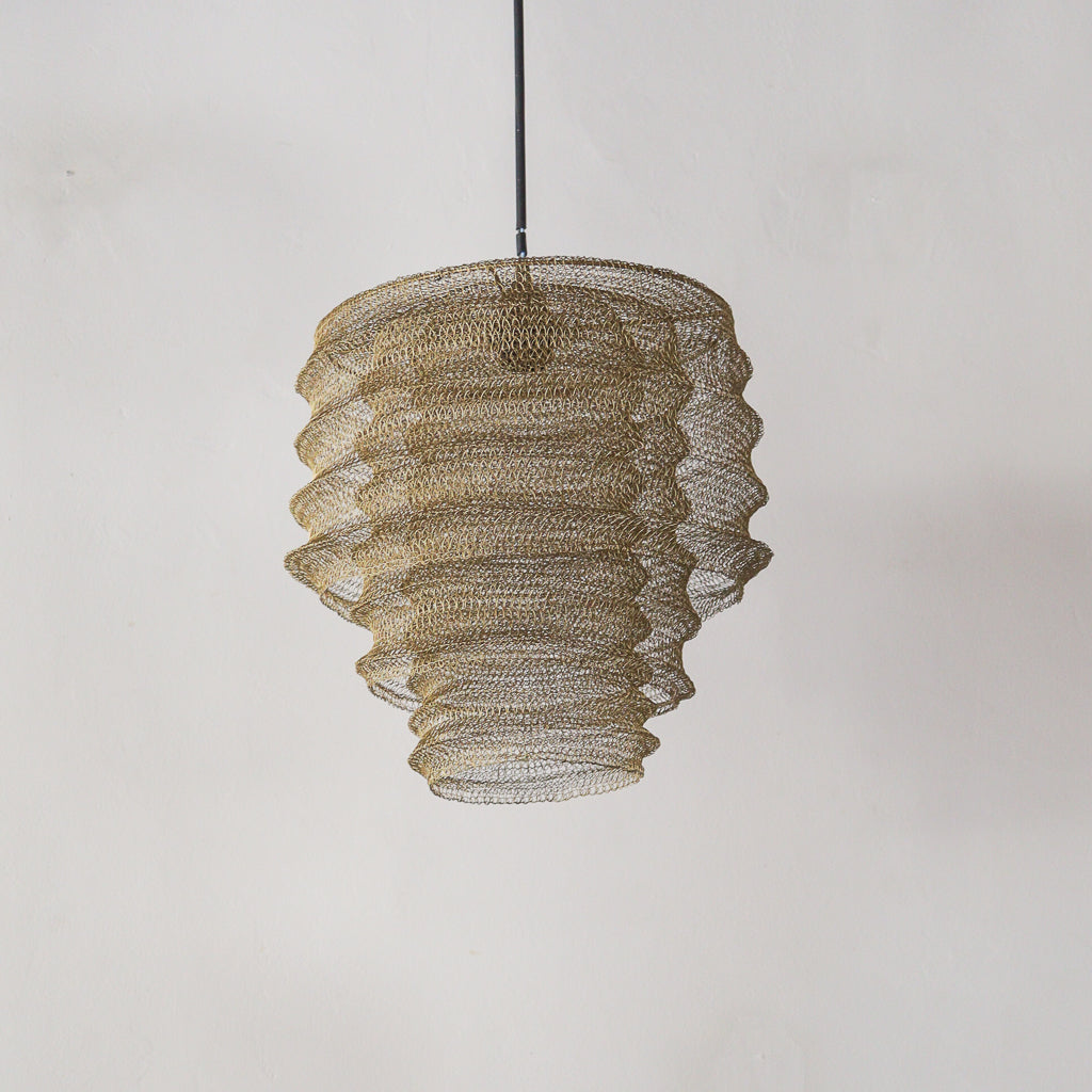 Decorative pendant light with a textured design on a plain background