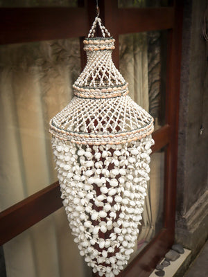 Handmade Balinese seashell chandelier with intricate shell beads, hanging outdoors