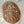 Hand-carved wooden wall art featuring a tree with branches and leaves on a round panel
