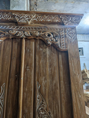 Hand-carved Balinese wooden door with intricate artisan floral patterns