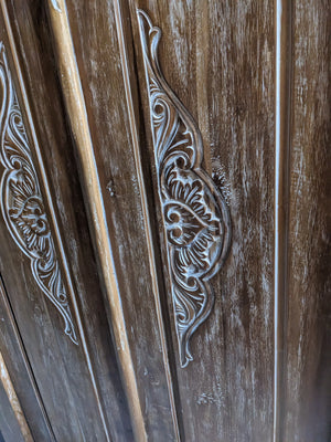Hand-carved Balinese wooden door with intricate floral detailing