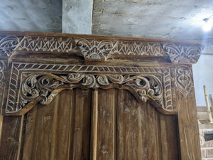 Hand-carved Balinese wooden door with intricate floral and geometric patterns