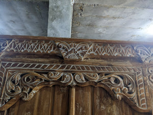 Hand-carved Balinese wooden door with intricate floral and geometric detailing