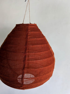 Handmade brown woven hanging pendant lamp with natural fiber cord against white wall