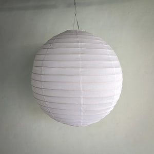 White paper lantern hanging against a plain wall, minimalist home decor lighting