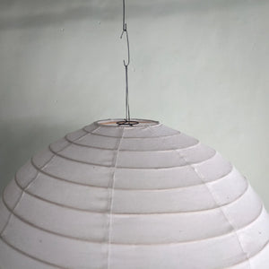 Handmade white paper lantern pendant light with spiral design, hanging from ceiling