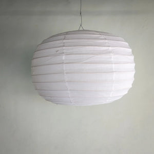 White round paper lantern hanging pendant light against plain wall, minimalist home decor