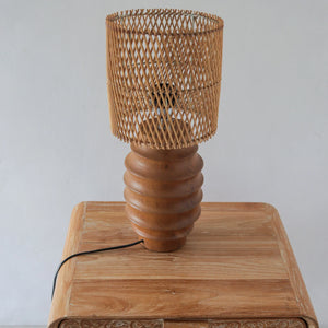 Handmade rattan night lamp with wooden base on wooden table, eco-friendly home decor