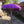 Purple Balinese decorative parasol with tassels in a traditional stone courtyard