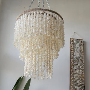 Handmade seashell chandelier with natural shells, hanging in a minimalist room decor setting