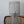 Metal wire mesh lampshade on a wooden chair against a plain background