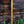 Hand-carved teakwood parasol pole with intricate patterns against brick wall outdoors