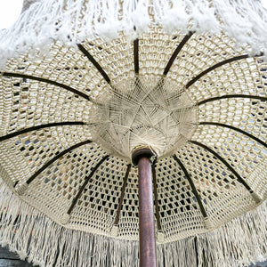 Handmade white macrame Balinese umbrella with wooden pole and decorative fringe