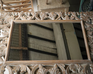 Hand-carved wooden frame mirror with intricate floral patterns, artisanal home decor