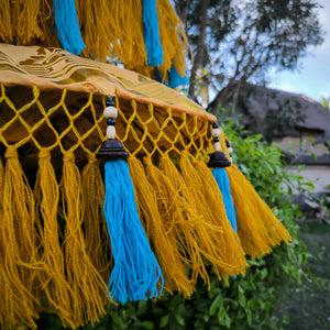 Handmade yellow gold fringe with blue tassels and beads, outdoor Balinese decor detail