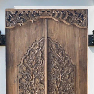 Hand-carved Balinese wooden double door with intricate floral patterns