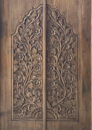 Hand-carved Balinese wooden double door with intricate floral patterns
