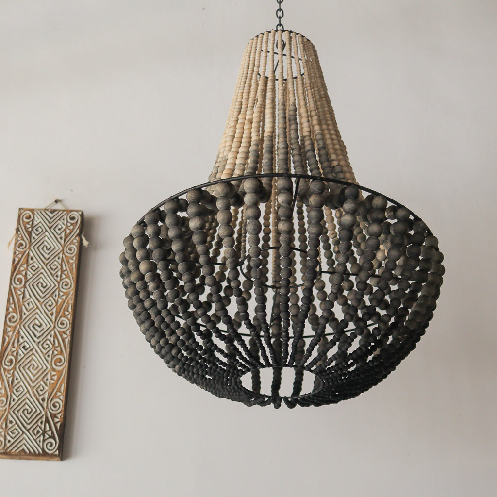 Decorative chandelier with wooden beads on a plain wall