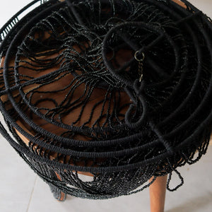 Close-up of a handmade beaded chandelier in black, showcasing intricate design and craft from Bali, Indonesia.