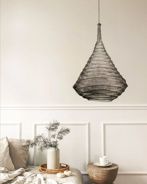 Black wire mesh lampshade in modern living room with neutral decor and cozy bed