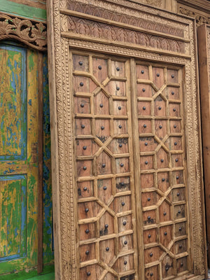 Hand-carved Balinese wooden door with geometric patterns and ornate frame