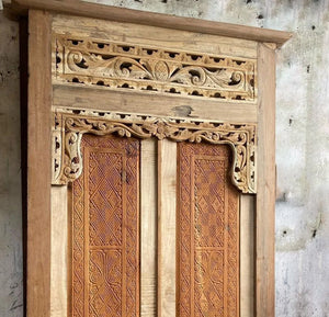 Hand-carved Balinese wooden door with intricate floral and geometric details