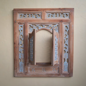 Hand-carved wooden window frame with intricate Balinese floral patterns