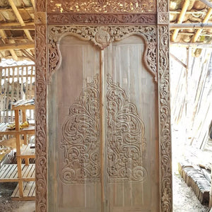 Hand-carved Balinese teak wood door with intricate floral and scrollwork patterns