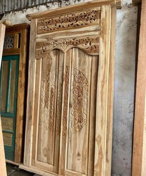 Hand-carved Balinese teak wood door with intricate floral and scrollwork designs